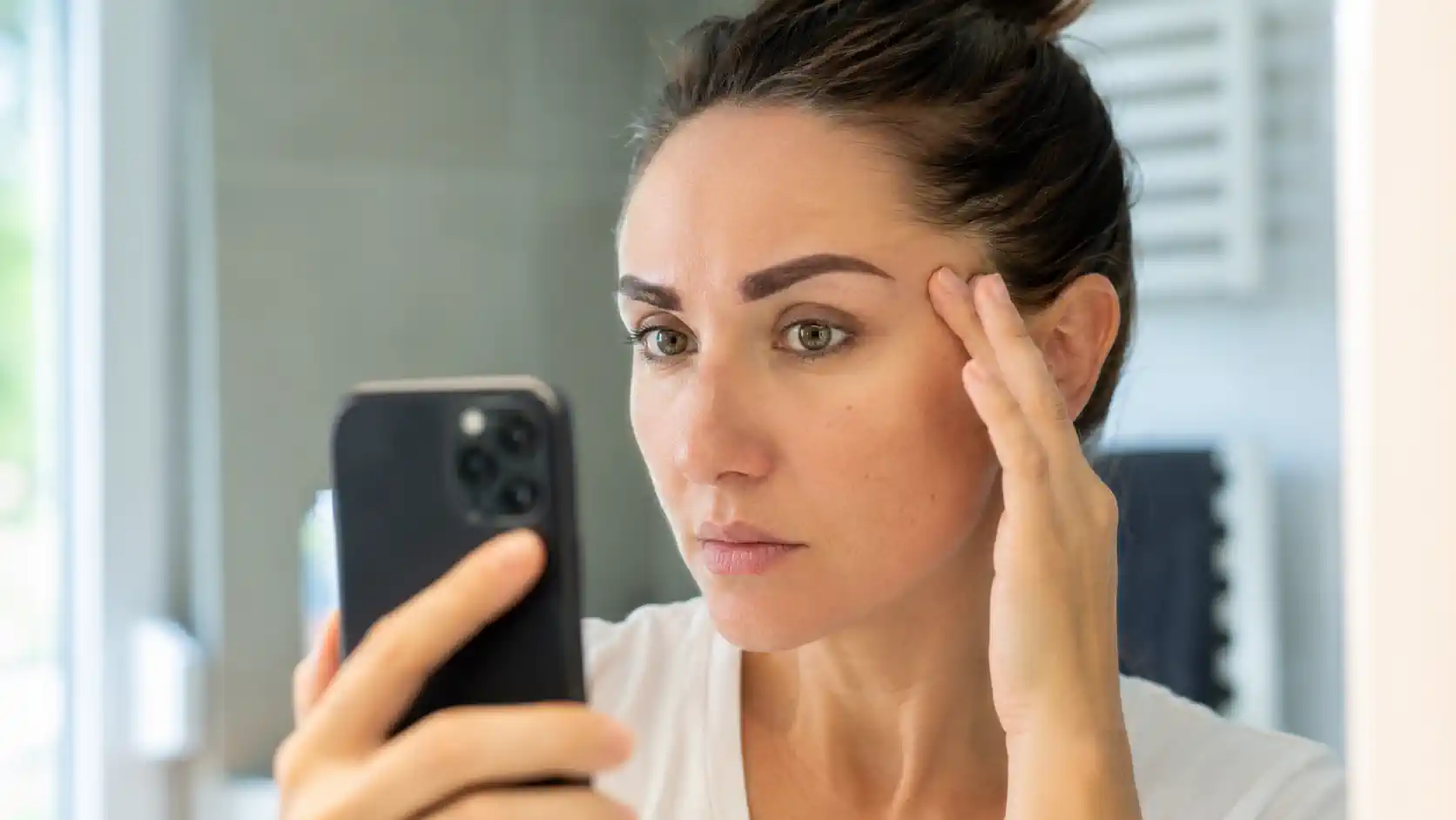 Femme observant ses sourcils après un microblading raté