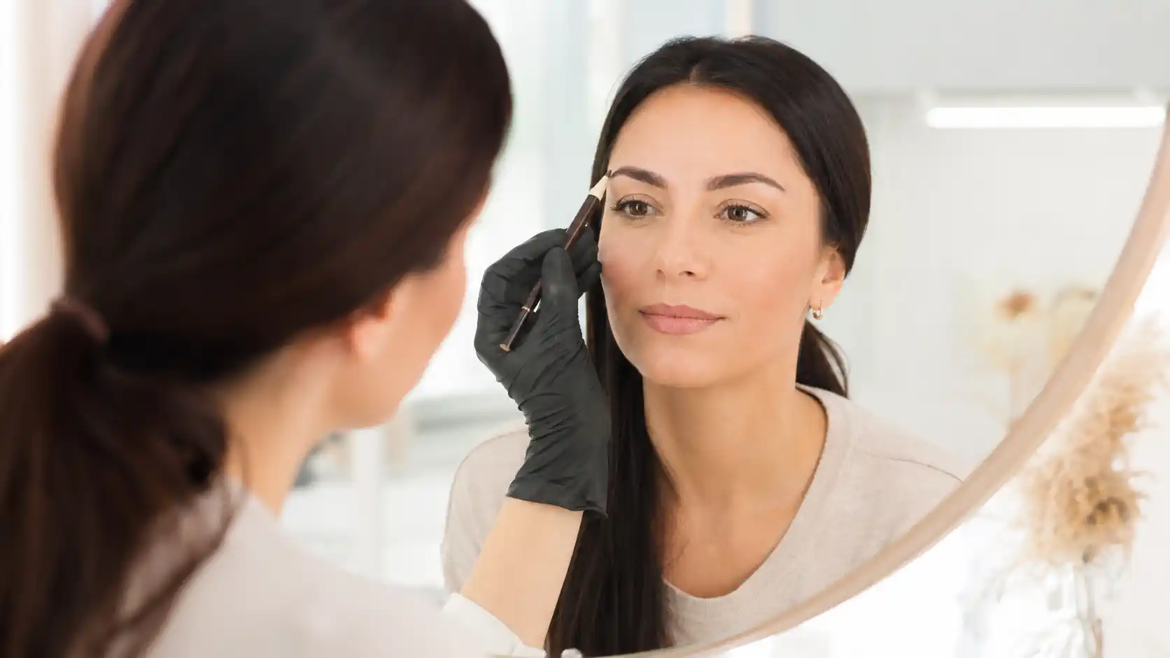 Professionnelle préparant le tracé des sourcils avant un microblading